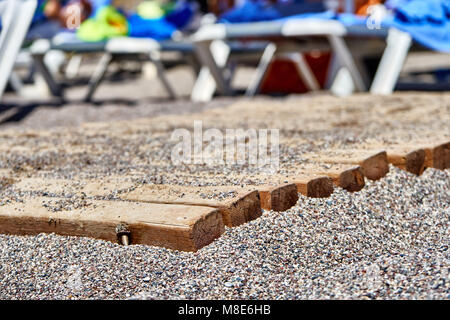 Chemin en bois sur la plage de galets pour une marche confortable jusqu'à l'eau de très près Banque D'Images