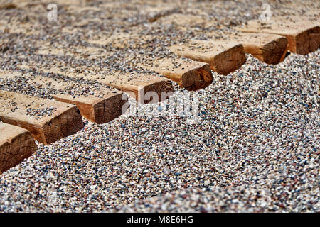 Chemin en bois sur la plage de galets pour une marche confortable jusqu'à l'eau de très près Banque D'Images