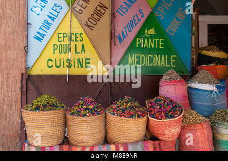 Des paniers et des sacs remplis d'ingrédients naturels pour la cuisson et à des fins médicinales à l'extérieur d'un restaurant dans un marché aux épices à Marrakech, Maroc. Banque D'Images