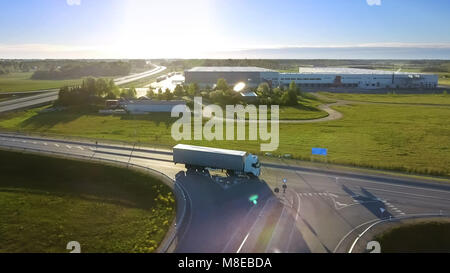 Vue aérienne de camion blanc semi avec remorque Cargo passant Viaduc/ Pont. 18 Wheeler est nouveau, les entrepôts de chargement sont vus dans le Backg Banque D'Images