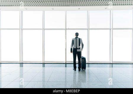 Silhouette d'image avec une assurance à la recherche d'une fenêtre à l'aéroport Banque D'Images