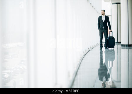 L'homme d'affaires à l'aéroport international déménagement à la borne d'embarquement pour voyager en avion voyage. Banque D'Images