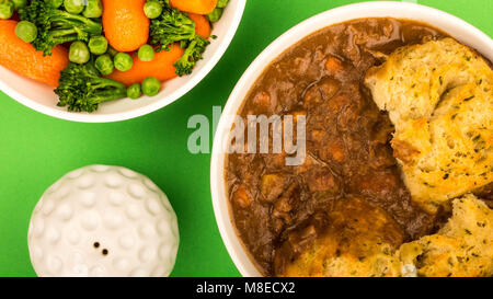 Goulasch de Bœuf britannique traditionnel, avec des boulettes sur un fond vert et un bol de légumes Banque D'Images