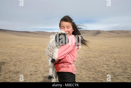 Hatgal, la Mongolie, le 2 mars 2018 : nomade mongol fille avec son animal de moutons dans une steppe Banque D'Images