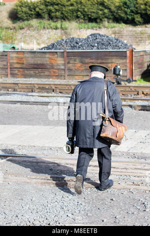 Kidderminster, Royaume-Uni. 16 mars 2018. Les amateurs de chemin de fer de Severn Valley bénéficient d'un premier jour réussi du Gala de la vapeur de printemps. Avec le soleil en abondance, les foules affluent vers ce chemin de fer patrimonial pour se faire plaisir à leur passion pour les trains à vapeur britanniques d'époque, tandis que les cheminots sont tenus à plat toute la journée. Ce garde ferroviaire, transportant la lampe de train, est à pied, allant à la maison, après une journée très occupée à faire du chemin de fer. Crédit: Lee Hudson/Alay Live News Banque D'Images