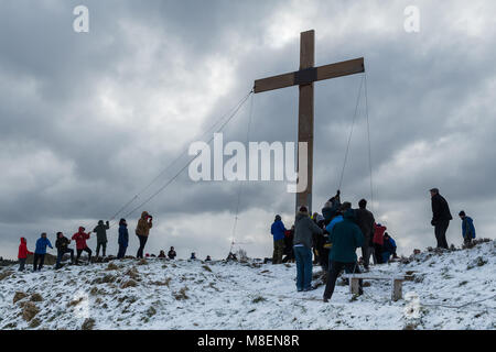 Otley Chevin, Royaume-Uni, le 17 mars 2018. Un matin froid et enneigé, des bénévoles des églises locales, en utilisant des cordes, élèvent l'énorme, lourd, en bois, Croix de Pâques sur le Chevin, une haute crête surplombant la ville d'Otley, West Yorkshire, Angleterre, Royaume-Uni. Un symbole chrétien de foi et d'espoir. Crédit : Ian Lamond/Alay Live News Banque D'Images