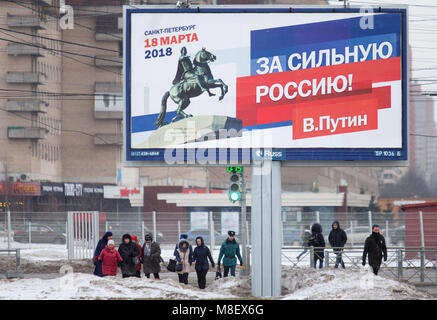 Saint-pétersbourg, Russie. 17Th Mar, 2018. Les gens à pied près d'une affiche électorale pour le président russe Vladimir Poutine dans une rue de Saint-Pétersbourg. Crédit : Igor Russak SOPA/Images/ZUMA/Alamy Fil Live News Banque D'Images