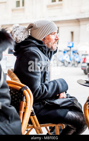 Un gars bien habillé se bloque dans un café typiquement français dans la ville balnéaire de Nice, France. Banque D'Images