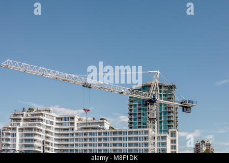 Crane construit des immeubles modernes et les bâtiments sur une journée d'été contre un ciel bleu et nuages blancs Banque D'Images