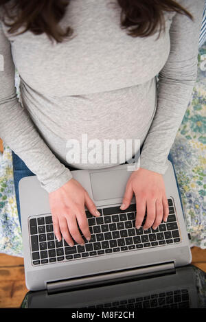 High angle view of pregnant woman using laptop Banque D'Images