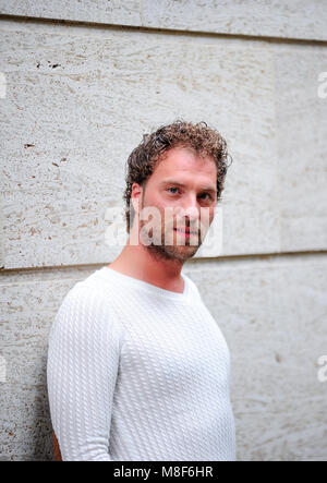 Bel homme debout contre un mur Banque D'Images