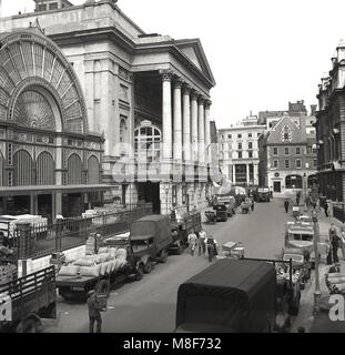 Années 1950, photo historique montrant l'activité générale en dehors de l'immeuble de grand columed la Royal Opera House de Bow Street, Covent Garden au célèbre marché de fruits et légumes en gros au centre de Londres, Angleterre, Royaume-Uni. Banque D'Images