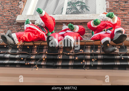 Trois poupées Santa vous asseoir sur un parasol Banque D'Images