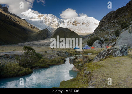 Camping dans le désert à distance des Andes au Pérou avec des montagnes enneigées et un ruisseau de montagne turquoise calme Banque D'Images