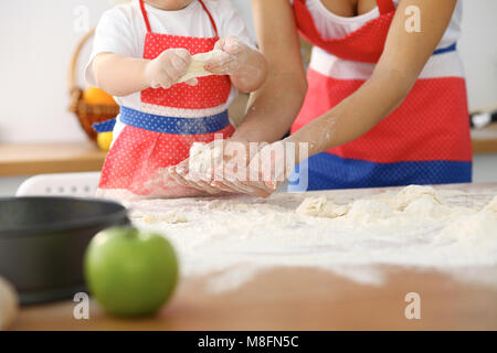 Mère et son joli fille mains prépare la pâte sur la table en bois. Pâtisserie Maison pour le pain ou la pizza. Arrière-plan de boulangerie Banque D'Images