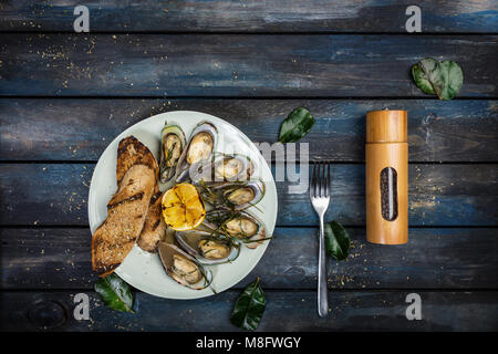 Les moules et toasts de pain sur sur une plaque blanche. Vue d'en haut Banque D'Images