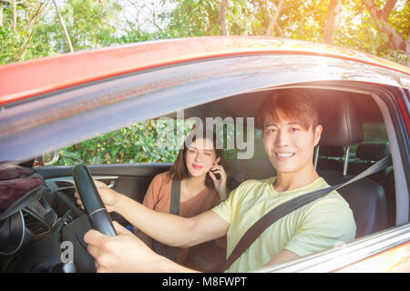 Happy young couple sitting dans la voiture Banque D'Images