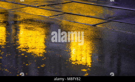 Les lumières de la ville le soir après la pluie, phares de la voiture. Vue depuis le niveau de la chaussée Banque D'Images