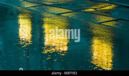 Les lumières de la ville le soir après la pluie, phares de la voiture. Vue depuis le niveau de la chaussée Banque D'Images