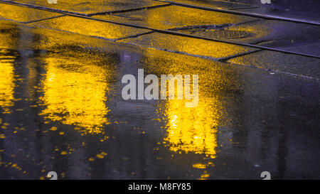 Les lumières de la ville le soir après la pluie, phares de la voiture. Vue depuis le niveau de la chaussée Banque D'Images