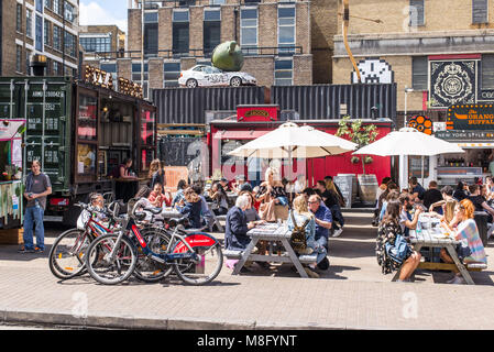 Pop up stands restaurants en plein air avec des gens de manger sur des tables outiside à l'Old Truman Brewery, Ely's Yard, Shoreditch, London, UK Banque D'Images