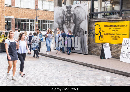 Les personnes bénéficiant de l'été chaud à l'Old Truman Brewery, Ely's Yard, Shoreditch, London, UK Banque D'Images