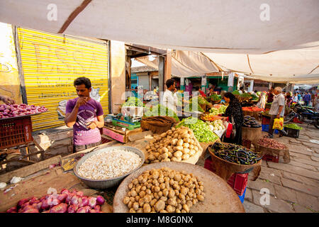 Les commerçants vendent des produits d'accueil à la tour du marché de l'horloge à Jodhpur, Inde au cours de chaude journée ensoleillée. Ils sont protégés par des nuances de tissu contre s Banque D'Images