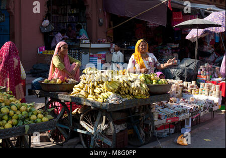 Les commerçants vendent des produits cultivés à la maison du marché de l'horloge tour de Jodhpur, Inde au cours de chaude journée ensoleillée. Les femmes sont en souriant, vêtu d'Erd colorés Banque D'Images