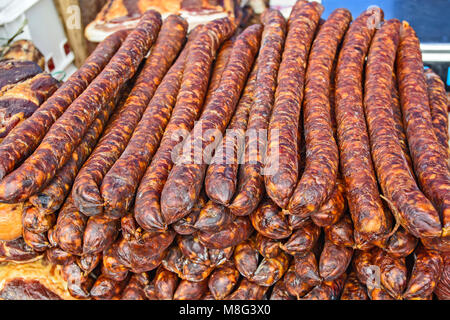 Des saucisses de porc fumé et séché debout sur la table pour la vente. Banque D'Images