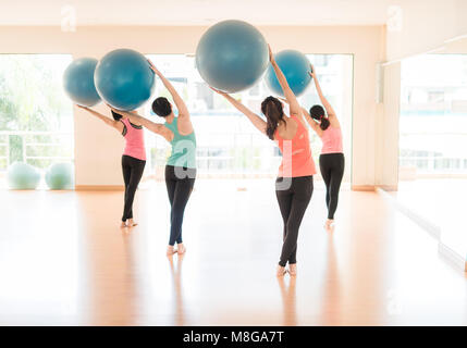 - Remise en forme les jeunes femmes chargées de l'Asie ou l'entraînement sportif l'entraînement avec ballon de gymnastique dans une salle de sport ballon bleu femelle en arrière miroir voir classe de Pilates Banque D'Images