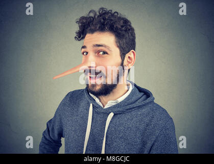 L'homme menteur avec long nez isolé sur fond gris. Les émotions humaines, de sentiments. Banque D'Images