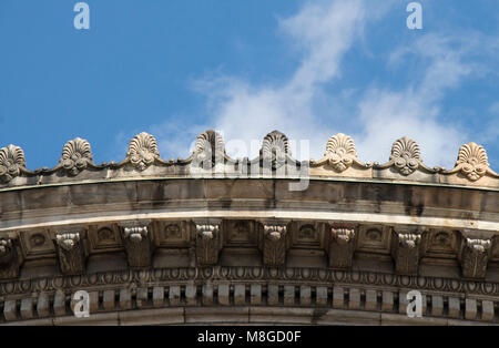 Détail d'un bâtiment néoclassique avec ornements corniche ronde contre un ciel bleu avec des nuages blancs Banque D'Images