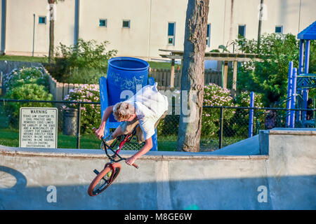 Adolescents sur leurs bicyclettes BMX la pratique de sauts à un skate park de Galveston au Texas. Banque D'Images
