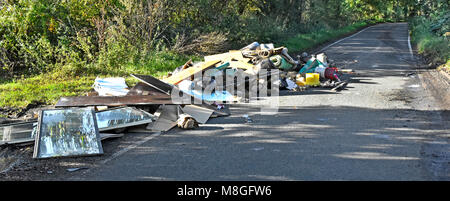 Les décharges sauvages de déchets divers, d'un camion à ordures détritus abandonnés sur la voie publique dans un pays lane Brentwood Navestock campagne de l'Essex England UK Banque D'Images