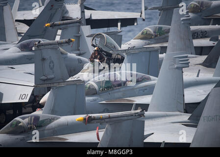 180315-N-NG033-1046 Golfe Arabique (15 mars 2018) lance le Cpl. Christopher Carter reçoit des instructions lorsque les freins équitation dans un F/A-18 Hornet, affecté à ce les damiers des Strike Fighter Attack Squadron (VMFA) 312, sur le pont du porte-avions USS Theodore Roosevelt (CVN 71). Theodore Roosevelt et son groupe aéronaval sont déployés dans le domaine de la 5e flotte américaine des opérations à l'appui des opérations de sécurité maritime pour rassurer les alliés et les partenaires et de préserver la liberté de navigation et la libre circulation du commerce dans la région. (U.S. Photo de la marine en masse Communicati Banque D'Images