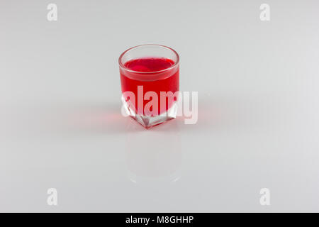 Un verre de l'eau rouge isoler en fond blanc Banque D'Images