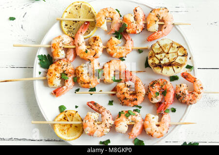 Brochettes de crevettes grillées. Fruits de mer, de bivalves. Brochettes de crevettes crevettes aux épices et herbes fraîches sur fond de bois blanc, copie de l'espace. Crevettes crevettes b Banque D'Images