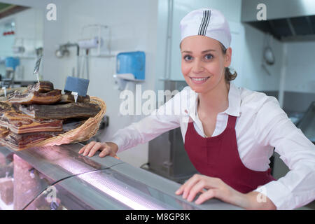 Portrait of happy female butcher standing in shop Banque D'Images