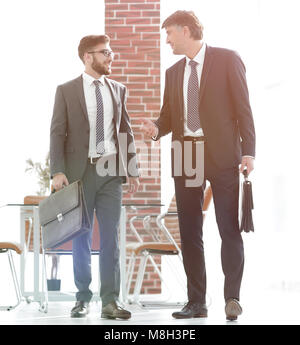 Deux hommes d'en marchant le long d'un immeuble de bureaux moderne Banque D'Images