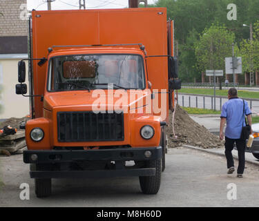 Camion rouge, orange et le nettoyage machine à la ville rue.avant-garde d'une brosse machine urbaine. ville voiture de service. Parking municipal pour Banque D'Images