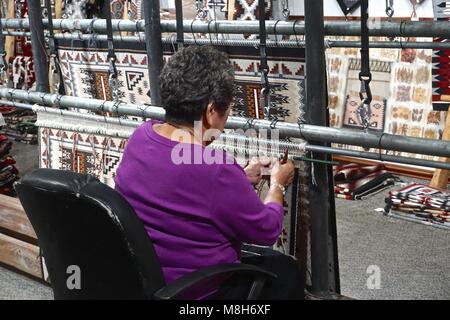 Cameron, AZ, USA : une femme Navajo traditionnel démontre au tissage de tapis Cameron Trading Post, un centre culturel américain. Banque D'Images