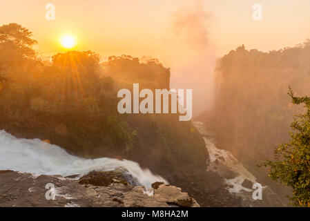 La lumière dorée d'un lever de soleil sur Victoria Falls au Zimbabwe. Banque D'Images