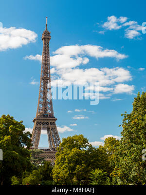 Belle vue de la tour Eiffel parmi les arbres verdoyants en été vert sur fond de ciel bleu Banque D'Images