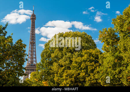 Belle vue de la tour Eiffel parmi les arbres verdoyants en été vert sur fond de ciel bleu Banque D'Images