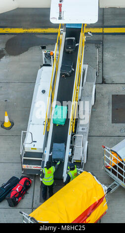 Londres Gatwick, 15 mars 2018 : point de vue des bagagistes ramasser des valises d'un convoyeur à bande connecté à un Airbus A320 d'easyJet a Banque D'Images