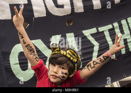 Athènes, Grèce. 17Th Mar, 2018. Une jeune fille met en place signe de la paix au cours du mois de mars. Les réfugiés ont défilé contre la fermeture des frontières et l'UE-Turquie traiter les laissant bloqués en Grèce. Anti-raciste, de gauche et les organisations des droits de l'organisé un rassemblement à l'occasion de la semaine d'action européenne contre le racisme, le fascisme et les politiques migratoires de l'UE. Credit : Nikolas Georgiou/ZUMA/Alamy Fil Live News Banque D'Images