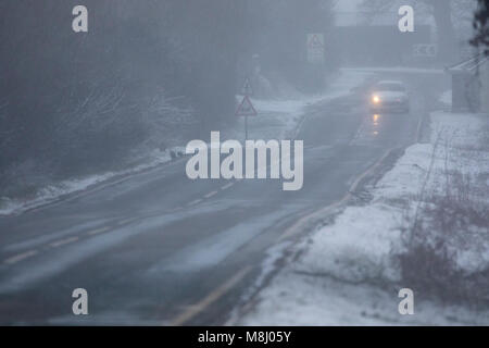 Flintshire, Pays de Galles, UK Met Office : Météo avec mises en garde en place pour la neige la Mini bête de l'Est apporte un froid à Flintshire avec gel et neige avec plus sur le chemin à travers les prochaines 24h. Une voiture roulant vers le bas et lane comme fortes chutes de neige dans le village de Caerwys, Flintshire Banque D'Images