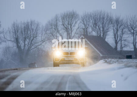 Flintshire, Pays de Galles, UK Met Office : Météo avec mises en garde en place pour la neige la Mini bête de l'Est apporte un froid à Flintshire avec gel et neige avec plus sur le chemin à travers les prochaines 24h. Une voiture roulant vers le bas et lane comme fortes chutes de neige dans le village de Caerwys, Flintshire Banque D'Images