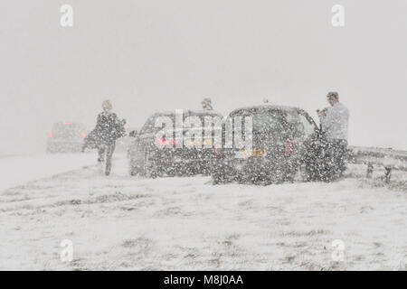 Long Bredy, Dorset, UK. 18 mars 2018. Météo britannique. Les gens de leurs véhicules après un accident impliquant 2 voitures qui a glissé hors de la route et a frappé les glissières de sécurité dans la centrale de réservation pendant un blizzard sur l'A35 à long Bredy entre Tampa et Dorchester, dans le Dorset comme beaucoup de neige qui a recouvert la route, rend la conduite dangereuse. Crédit photo : Graham Hunt/Alamy Live News. Banque D'Images