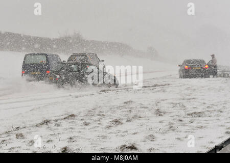 Long Bredy, Dorset, UK. 18 mars 2018. Météo britannique. (Séquence d'images d'un accident 2 de 5) une voiture dévie sur la route et l'accident en obstacles hits la centrale de réservation que le pilote est en mesure de s'arrêter pour éviter l'arrêt de voitures qui ont arrêté des conditions de blizzard sur l'A35 à long Bredy entre Tampa et Dorchester, dans le Dorset comme beaucoup de neige qui a recouvert la route, rend la conduite dangereuse. Crédit photo : Graham Hunt/Alamy Live News. Banque D'Images